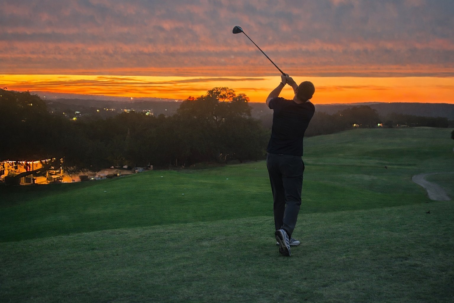 Golfer's follow-through against a Hill Country sunset at Lago Vista Golf Course